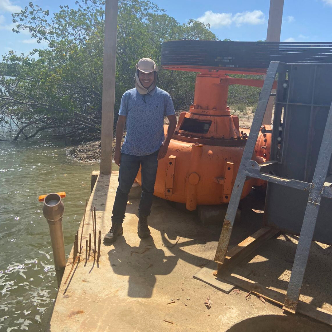 Aluno de graduação em Engenharia de Pesca Antony ao lado de uma das bombas de captação de água.