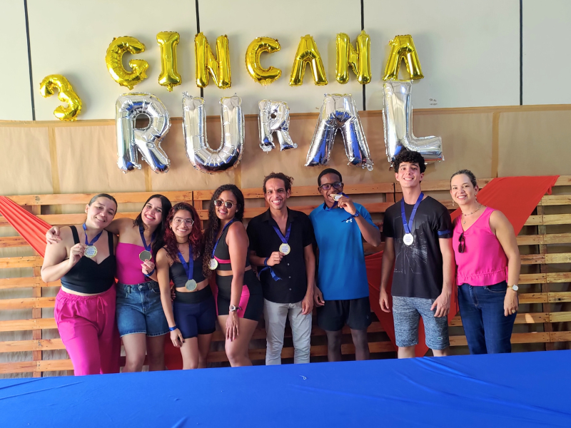 A professora Carolina Nunes Bonfim, diretora do CCAA, entregando medalhas de ouro, prata e bronze às equipes vencedoras.